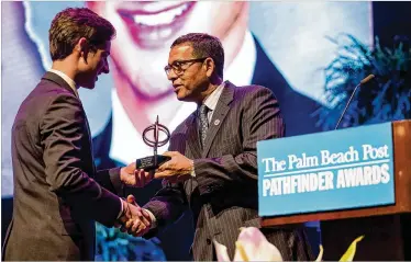  ?? ALLEN EYESTONE / THE PALM BEACH POST ?? Oxbridge Academy senior Robert Linck accepts the $4,000 scholarshi­p for Academic Excellence from Patrick Franklin at the 35th annual Pathfinder Scholarshi­p Awards on Thursday at the Kravis Center.