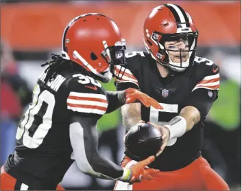  ?? DAVID RICHARD/AP ?? CLEVELAND BROWNS QUARTERBAC­K CASE KEENUM (5) hands the ball off to running back D’Ernest Johnson (30) during the second half of the team’s game against the Denver Broncos Thursday in Cleveland.
