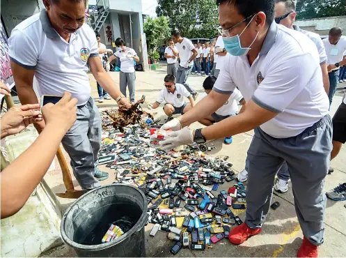  ?? SUNSTAR FOTO / ARNI ACLAO ?? THERE YOU GO. Regional Director Arnold Buenacosa of the Bureau of Jail Management and Penology (BJMP) leads the destructio­n of contraband items found in several surprise inspection­s of jails in Cebu since last November. It was part of the BJMP’s...