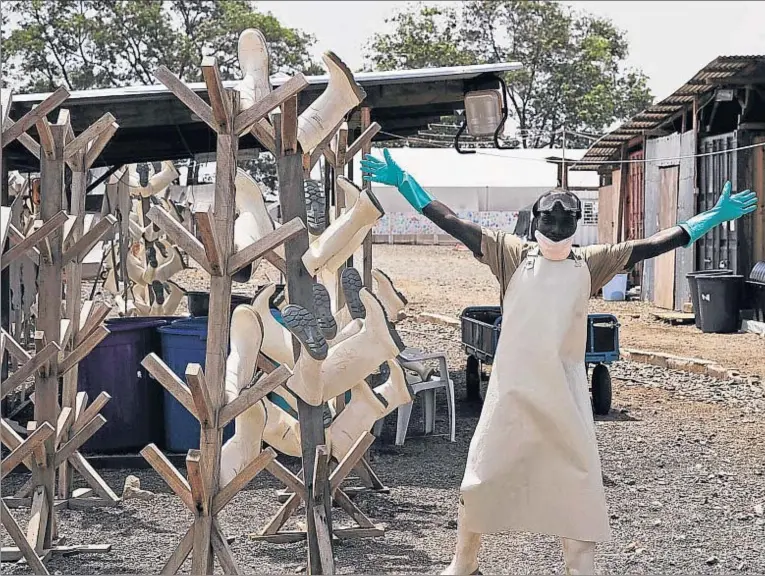  ??  ?? Un trabajador sanitario de Liberia, feliz al desmantela­r uno de los centros de tratamient­o del ébola habilitado­s en Monrovia