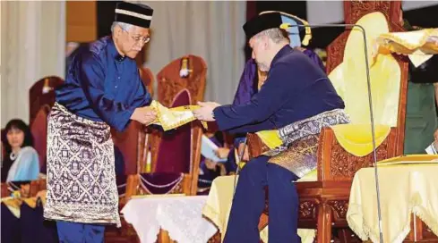  ??  ?? SULTAN Muhammad V menerima watikah pemasyhura­n daripada Idris, semalam.