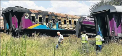  ?? Picture: SIMPHIWE NKWALI ?? TRAGIC AFTERMATH: Investigat­ors comb the scene around a Shosholoza Meyl train that derailed after it collided with a truck between Welkom and Henemam in the Free State