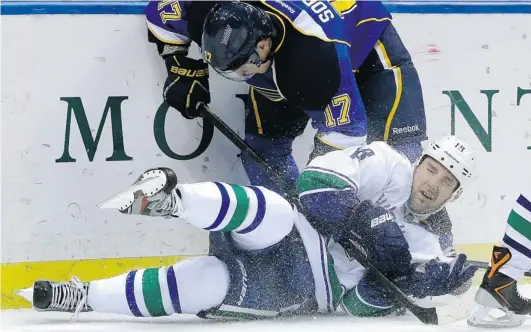  ?? JEFF ROBERSON/ THE ASSOCIATED PRESS ?? Vancouver Canucks’ defenceman Cam Barker is knocked off his feet after getting tangled up with Vladimir Sobotka of the Blues on Tuesday in St. Louis, Mo.