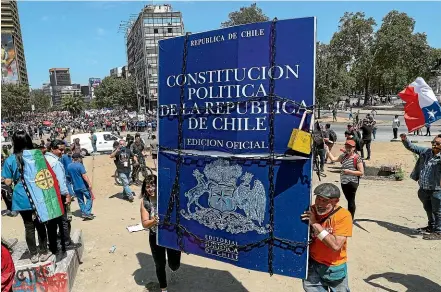  ?? AP ?? Anti-government demonstrat­ors carry a sign representi­ng Chile’s constituti­on during protests in Santiago.