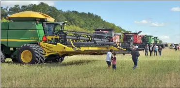  ??  ?? Combines stand ready to harvest a canola crop for Rock Solid Refuge, Aug. 31.