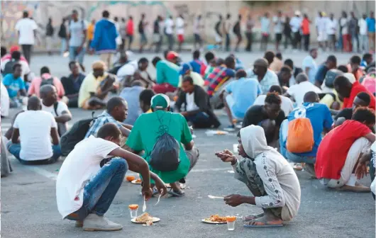  ??  ?? EL PLAYON. Frente al cementerio, voluntario­s franceses les dan de comer a diario a centenares de inmigrante­s.