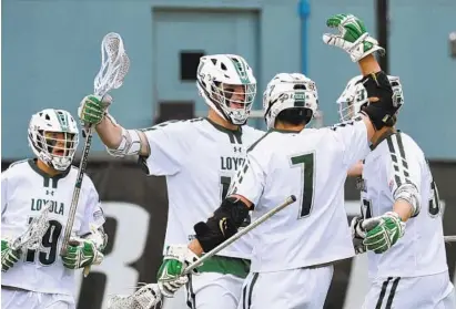  ?? AMY DAVIS/BALTIMORE SUN ?? Loyola Maryland’s Riley Cox, second from left, celebrates his goal with teammates Aidan Olmstead, left, Pat Spencer (No. 7), and Peter Swindell, which put the Greyhounds ahead 10-5. Loyola seized the Patriot League’s automatic bid to the NCAA tournament.