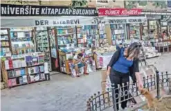  ??  ?? ISTANBUL: A woman pets a cat as shopkeeper­s sit outside bookstores in Istanbul. An increasing number of highly-skilled Turks are leaving Turkey, pushed by the flagging economy and what critics say are attacks on individual liberties. — AFP