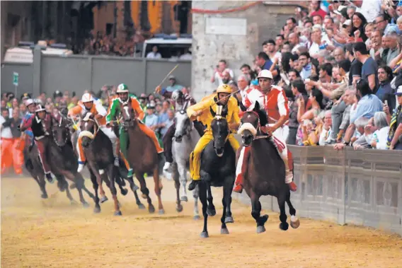  ?? Photos by Claudio Giovannini / AFP / Getty Images ?? Riders representi­ng 10 neighborho­ods compete in the centuries-old Palio di Siena horse race last month, with citywide bragging rights on the line.