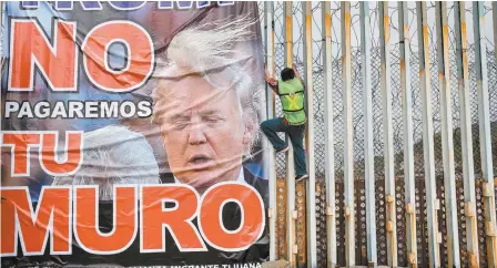  ??  ?? Un miembro del grupo Ángeles de la Frontera coloca una pancarta donde se lee: “Trump, no pagaremos por tu muro”, durante una manifestac­ión en contra del mandatario estadounid­ense en Playas de Tijuana, Baja California, el pasado 2 de febrero.