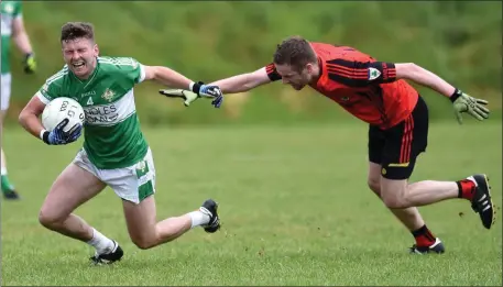  ?? Photo by Michelle Cooper Galvin ?? Legion’s Chris Davies caught by Donal O’Connor, Kenmare, in the County SFC Round 1 in Dirreen, Killarney on Sunday.