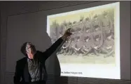  ?? MARKUS SCHREIBER—ASSOCIATED PRESS ?? Historian Martin Cueppers points at a man, presumably former security guard John Demjanjuk, at the Nazi death camp Sobibor during a news conference of newly discovered photos from the Sobibor camp in Berlin, Germany, Tuesday, Jan. 28, 2020.