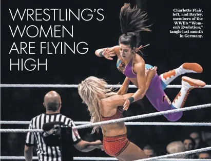  ?? LUKAS SCHULZE, BONGARTS/ GETTY IMAGES ?? Charlotte Flair, left, and Bayley, members of the WWE’s “Women’s Evolution,” tangle last month in Germany.