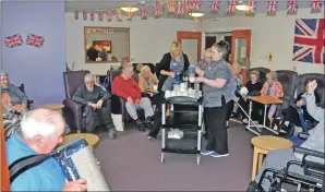  ?? 20_c25carehom­e03 ?? Alex MacKinnon entertains the residents, while staff keep the tea and coffee flowing.