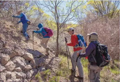  ?? LIAM DEBONIS/FOR THE JOURNAL ?? Members of the New Mexico Mountain Club climb a steep slope to access the trail to Cedro Peak during a hike in April.