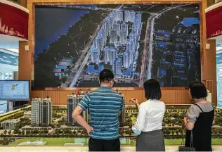  ?? Photos by Gilles Sabrie / New York Times ?? A salesperso­n, center, meets with visitors in the sales office for Evergrande Mansions in Dongguan, China, in September. On Thursday, Fitch Ratings declared Evergrande was in default.