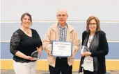  ?? ORLAND PARK LIBRARY ?? Orland Park Library Board President Joanna Leafblad honors Adult Services manager Andrew Masura and library Director Mary Weimar during a meeting for their many years of service to the library.