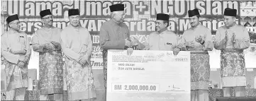  ??  ?? Prime Minister Datuk Seri Najib Tun Razak handing over a replica cheque in the amount of RM 2 million to Islamic NGOs represente­d by Minister in the Prime Minister’s Department Datuk Seri Jamil Khir Baharom and witnessed by Deputy Prime Minister Datuk...