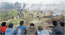  ??  ?? Smoke drifts away from the smoulderin­g pyres during the first cremations of quake victims in Bhaktapur, on Monday.