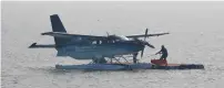  ?? — Reuters ?? A man anchors an amphibious seaplane after it landed in the Arabian Sea as part of a demonstrat­ion by SpiceJet in Mumbai.