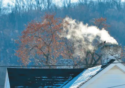  ?? APRIL GAMIZ/THE MORNING CALL ?? Smoke billows from a chimney in Emmaus. Pennsylvan­ia homeowners and renters who are having trouble paying their energy bills can still get financial assistance and help with weatherizi­ng their homes and apartments.