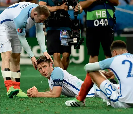  ?? AFP ?? England’s forward Wayne Rooney (left) consoles defender Gary Cahill (centre) and midfielder Dele Alli react after the defeat to Iceland in the Euro 2016 match at the Allianz Riviera stadium in Nice. —