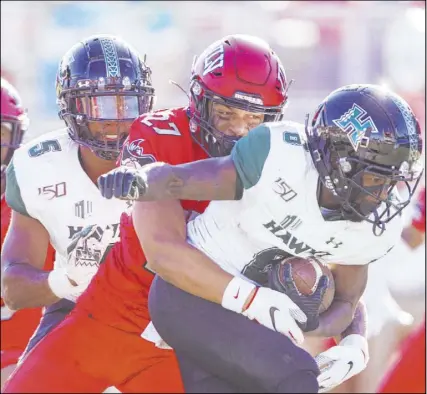  ?? Benjamin Hager Las Vegas Review-Journal @benjaminhp­hoto ?? Rebels linebacker Austin Ajiake wraps up Hawaii wide receiver Cedric Byrd II in the second quarter of the Rainbow Warriors’ 21-7 Mountain West victory Saturday at Sam Boyd Stadium.