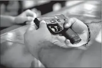  ?? Ricardo Ramirez Buxeda / Orlando Sentinel /TNS ?? A customer looks at a handgun at the Kissimmee, Florida, location ofthe Armories on Dec. 31, 2020. From 2019 to 2020, homicides involving firearms rose 35% to 6.1 per 100,000 people, a new CDC report says.