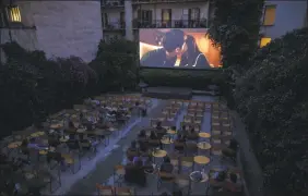  ?? Petros Giannakour­is / Associated Press ?? In this June 3 photo, moviegoers watch the 2019 South Korean black comedy film Parasite at the Panathinea outdoor cinema in Neapoli, central Athens.