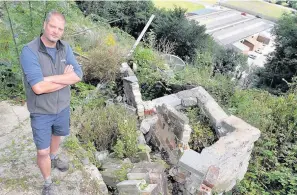  ??  ?? > Paul Harris in what is left of his back garden in Cyfyng Road, Ystalyfera