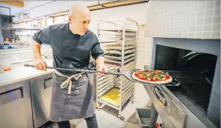  ?? PHOTOS: JOHN MAHONEY ?? Chef/co-owner Vincent Châtelais fills up Heirloom Pizzeria’s wood-burning oven.