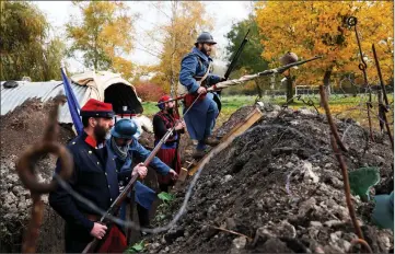  ??  ?? History enthusiast­s, members of French associatio­n Tempus Fugit, dressed in World War One French military out ts, re-enact daily life of soldiers during trench warfare, in Ecourt-Saint-Quentin, France.