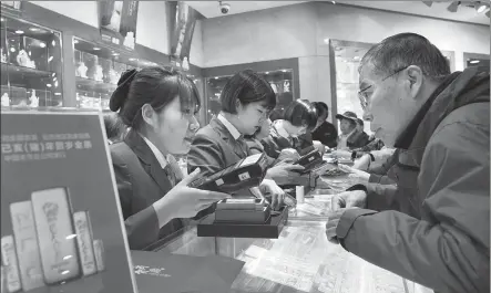  ?? PROVIDED TO CHINA DAILY ?? Staff of Beijing Caibai Department Store introduce the New Year gold bars to customers on Nov 20, 2018.