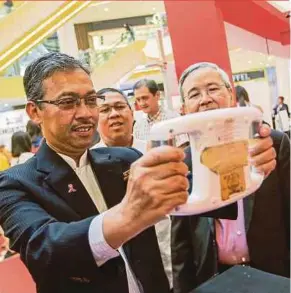  ?? PIC BY HAFIZ SOHAIMI ?? Health (Public Health) deputy director-general Datuk Dr Azman Abu Bakar checking out body fat measuremen­t tools after launching the World Health Day 2018 in Kuala Lumpur yesterday.