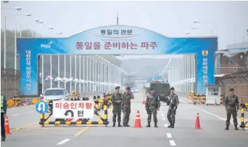  ?? — Reuters ?? South Korean soldiers stand guard at a checkpoint on the Grand Unificatio­n Bridge that leads to the Peace House, the venue for the Inter-korean summit, near the demilitari­sed zone separating the two Koreas, in Paju.