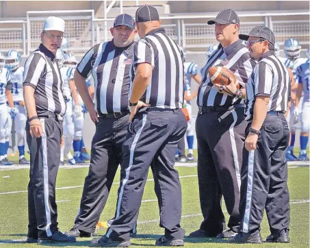  ?? JIM THOMPSON/JOURNAL ?? Officials, including referee Burt Melancon, left, gather during the Cibola/Carlsbad football game. The New Mexico Activities Associatio­n is in “crisis mode” due to a lack of officials to call games in the state. The athletics organizati­on says there is...