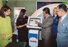  ?? PIC BY SADDAM YUSOFF ?? Second Finance Minister Datuk Seri Johari Abdul Ghani (third from left) testing the imSME terminal after the launch of Credit Guarantee Corp Malaysia Bhd’s (CGC) imSME platform in Kuala Lumpur yesterday. With him are (from left) Bank Negara Malaysia...