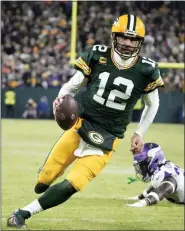  ?? MORRY GASH — THE ASSOCIATED PRESS ?? Green Bay Packers quarterbac­k Aaron Rodgers sprints past Minnesota Vikings linebacker Brian Asamoah II, for a twoyard touchdown run in the Packers’ win Sunday.