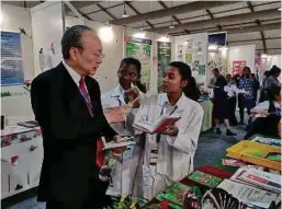  ??  ?? Kayalvizhi Manivannan (right) explaining her invention to C.I.S Network Sdn Bhd president Datuk Vincent Lim while her team member, Poovizhi Manivannan, looks on.