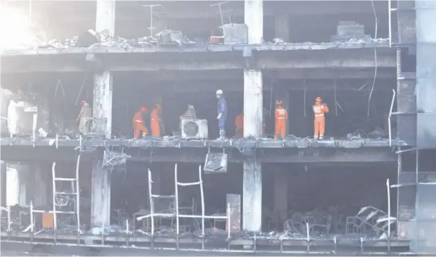  ?? Reuters ?? ↑
National Disaster Response Force and fire brigade personnel conduct a search and rescue operation after a fire broke out in a commercial building in New Delhi on Saturday.