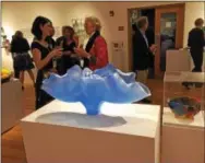 ?? SUSAN GREENSPON PHOTO ?? Guests mingle in the “Breaking the Glass Ceiling: Women In Glass” exhibit.