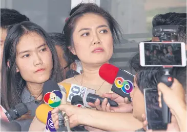  ?? APICHIT JINAKUL ?? Nicha Kiartthana­paiboon, 24, left, an unwitting suspect in a call centre scam after her missing ID card was used by others to open bank accounts, along with her elder sister, Punyada Kokmas, 33, talks to the press at Huai Khwang police station.