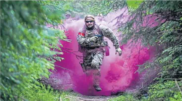  ?? ?? A competitor runs through the smoke to attack the enemy base at Fife Wargames, held at Cairngreen Wood.