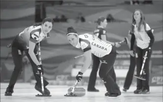  ?? MARK SCHIEFELBE­IN, THE ASSOCIATED PRESS ?? Canada’s Lisa Weagle, left, and Joanne Courtney sweep Rachel Homan’s stone against Russia Friday. Canada won 7-3 to advance to Sunday’s world championsh­ip final.