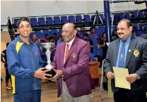  ??  ?? Best boxer in the men’s category N.M. Hettiarach­chi of MAS Slimline receiving the trophy from chief guest Sumith Liyanage retired DIG and former Sri Lanka boxer.