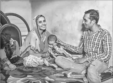  ??  ?? Rajeena sits with her children and her husband, Mohammad Sagir, 25, an electricia­n who attends a gender sensitivit­y class and recently permitted her to leave the village by herself for the first time. — The Washington Post photos by Poulomi Basu.