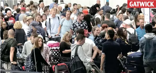  ??  ?? Going nowhere: Dozens of passengers wait in queues after IT meltdown yesterday