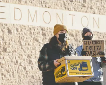  ?? DAVID BLOOM ?? Free Transit Edmonton organizers Paige Gorsak, left, and Cole Rockarts prepare to deliver a petition Monday with 1,400 signatures demanding city council freeze public transit cash fares.