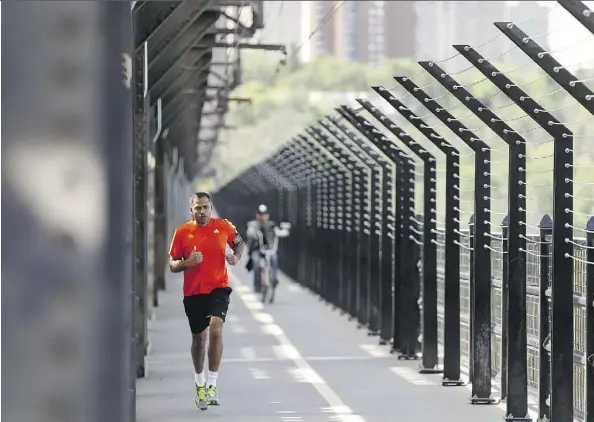  ?? IAN KUCERAK ?? A runner crosses the west sidewalk of the High Level Bridge on Thursday. The west sidewalk will be closed beginning June 20 to allow for the continued installati­on of safety barriers.