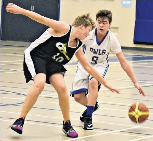  ?? DESIREE ANSTEY/JOURNAL PIONEER ?? Brandon Smith, a member of the Summerside Intermedia­te School (SIS) Owls, protects the ball from the Queen Charlotte Coyotes’ Jonah Murphy during play in the 43rd annual Glenn Edison Memorial tip-off basketball tournament hosted by SIS last weekend.